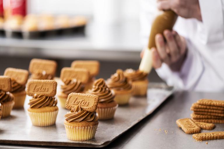 Baker piping Biscoff cupcakes